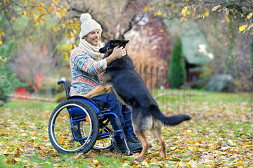 Mann mit Handicap im Rollstuhl mit seinem Hund 