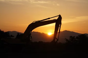 Fotobehang silhouette of excavator machine with sunset © yashis007