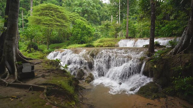 waterfall stream on nature clear flow motion water and green tree jungle in natural forest or rainforest at Kroeng Krawia waterfall in Thailand on rainy season for wild landscape with waterfall sound
