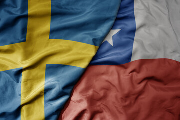 big waving national colorful flag of sweden and national flag of chile .