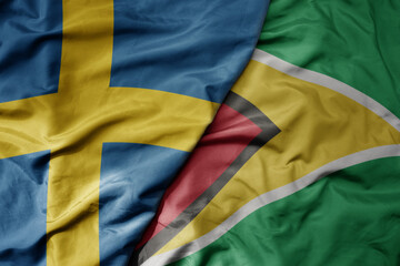 big waving national colorful flag of sweden and national flag of guyana .