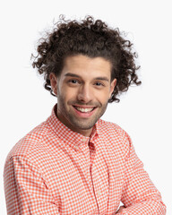handsome man with curly hair smiling and crossing arms