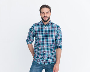 sexy unshaved man wearing casual plaid shirt holding hands in pockets