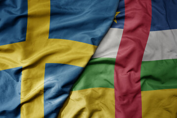 big waving national colorful flag of sweden and national flag of central african republic .