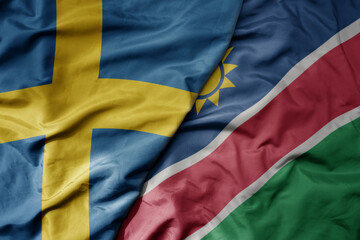 big waving national colorful flag of sweden and national flag of namibia .
