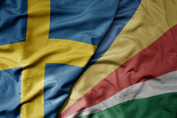 big waving national colorful flag of sweden and national flag of seychelles .