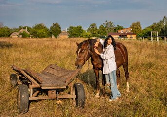 Fototapeta na wymiar Beautiful young caucasian woman standing near the horse.