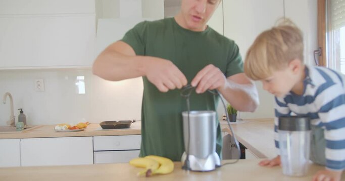 Trying to untie the cables of the juicer with his son on the kitchen counter