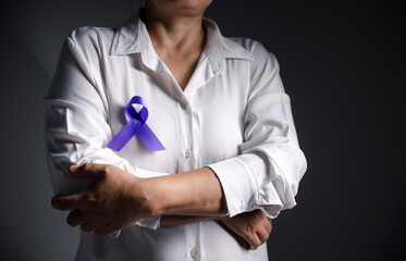 Woman with purple ribbon on grey background, closeup with space for text. Domestic violence...