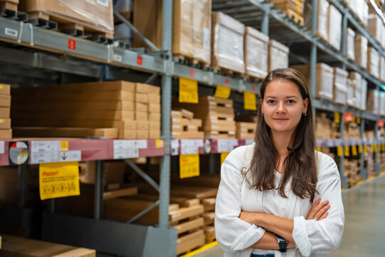 Portrait of woman customer or store worker with shelves in storage as background