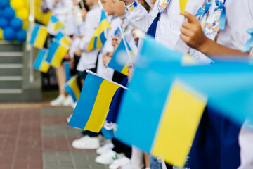 Many Ukrainian children hold the yellow and blue flag in their hands. The concept of the young generation of Ukraine.