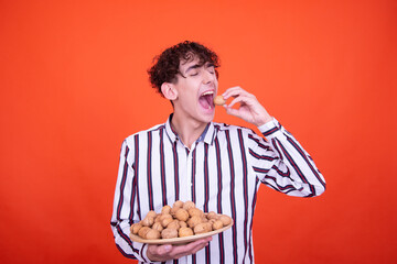 Funny curly guy posing in the studio on an orange background.