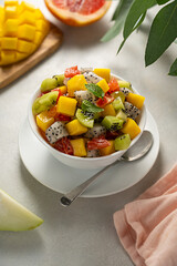 Exotic tropical fruit salad with fresh mango, dragon fruit, grapefruit, kiwi.