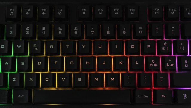 Modern backlit keyboard with pulsating rgb colour light. Panning video.
