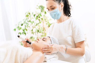 Dermastamp fractional mesotherapy in modern cosmetology clinic. Young woman at beautician's...