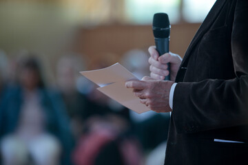Hintergrundbild einer Konferenz, Mensch mit einem Mikrofon 