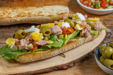 Sandwich with tuna salad on wooden background.