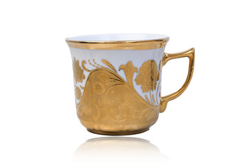 Antique porcelain coffee cup on white background with reflection. Dishes with gold pattern. Table...