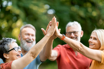 Portrait Of Happy Mature People Giving High Five To Each Other Outdoors - Powered by Adobe