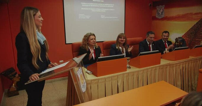 Professors applaud to the student for successfully passing the graduation exam and getting her diploma