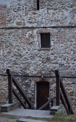 Building in medieval style with an entrance through an old door. Old wooden bridge