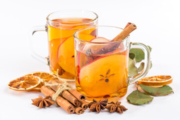 Concept of warm drinks for cold weather comfort. Side view image of a cup of apple cider, cinnamon sticks, dried orange and anise on a white background