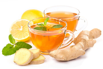 Idea of hot drinks for maintaining health. Side view image of a cup of ginger tea, lemon slices, mint leaves and ginger root on a white background