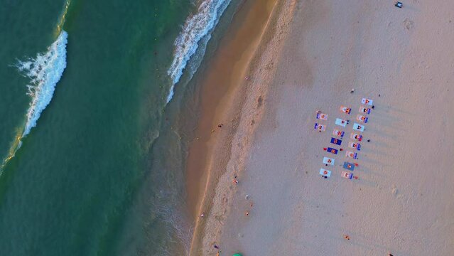 Landscape of My Khe beach, Da Nang, Vietnam with people practicing yoga, people walking for exercise and waves in the morning filmed from above.  Beach and people.  Travel concept, ocean sea backgroun