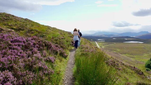 A man and a woman hiking through the Scottish mountains in an idyllic landscape, Scotland, UK.
