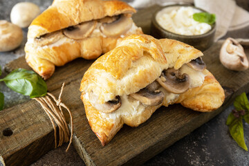 French pastry, tasty freshly baked sandwich. Vegan food style. Croissant with cream cheese and mushroom on a stone background.