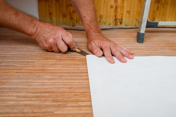Workers are preparing wallpaper for hanging.