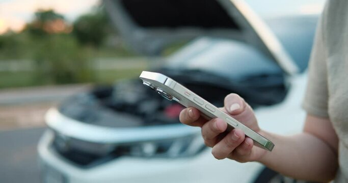 Close up hands of woman typing on smartphone asking for help when her car is broken. woman typing on smartphone asking for problem emergency insurance auto