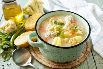 Low carb healthy eating. Cauliflower soup with chicken meatballs and vegetables on a wooden rustic...