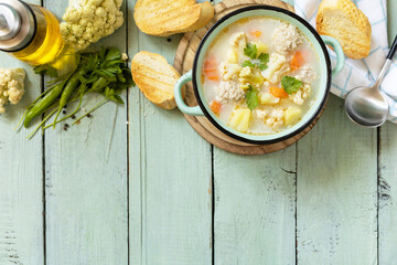 Low carb healthy eating. Cauliflower soup with chicken meatballs and vegetables on a wooden rustic table. View from above. Copy space.