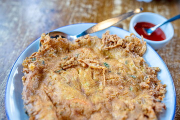 Close-up shallow field of view of Thai style omelet by mixing eggs with coriander and stirring well...