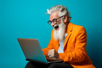Happy smiling elderly bearded man using laptop on blue  background