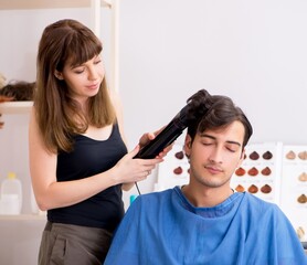 Young attracrive man visiting female barber