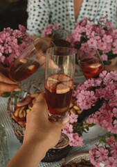 hands with glasses of aperitif together