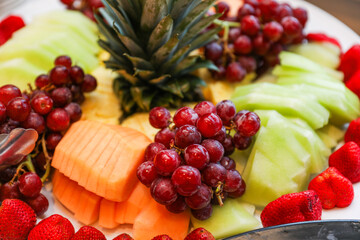 fruits, tomatoes, cheese, and charcuterie on a platter, symbolizing a delectable and balanced culinary experience
