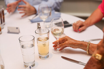 Hands clinking glasses, symbolizing celebration, toasts, and business success with wine, beer, or juice
