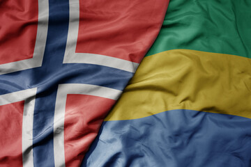 big waving national colorful flag of norway and national flag of gabon .