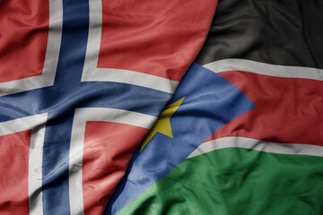 big waving national colorful flag of norway and national flag of south sudan .