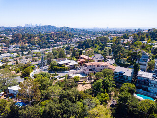 Fototapeta na wymiar Aerial view of the Los Feliz neighborhood with large houses in the hills and downtown Los angeles skyline in the background.