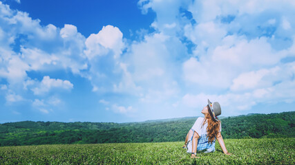 Asian women travel relax in the holiday. seats relax on the lawn on the mountain. In Thailand