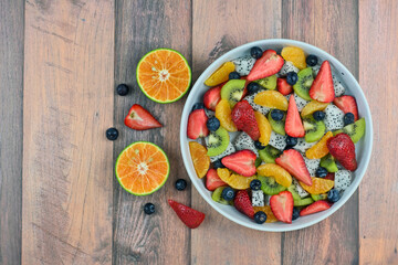 Fresh fruit salad bowl on wood grain table concept healthy food, to control weight, to lose weight