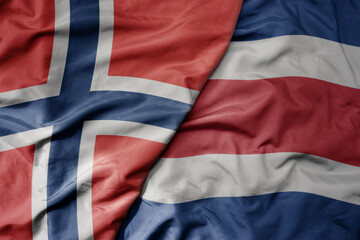 big waving national colorful flag of norway and national flag of costa rica .