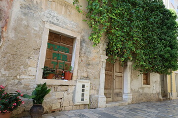 Fototapeta na wymiar Window of Mediterranean houses in town Porec, Croatia. Street of Porec with building facades in Croatia, Istria. 