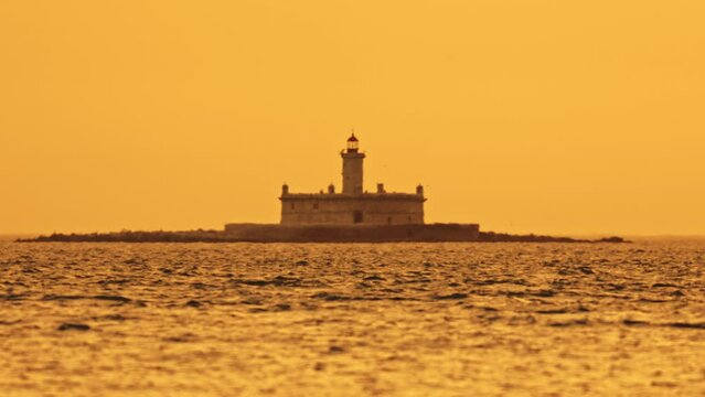 Bugio Lighthouse at orange foggy sunset