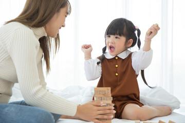 Happy loving family. Asian mother and her daughter child girl playing in bedroom.