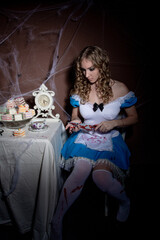 Halloween. Portrait of a young woman with a large kitchen knife. Dressed as Alice